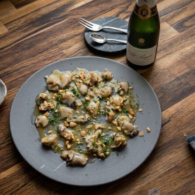 Grof gesneden oesters met beurre noisette, dragon, sjalot en gehakte hazelnoten als sharing gerecht.