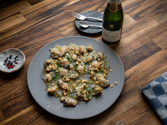 Grof gesneden oesters met beurre noisette, dragon, sjalot en gehakte hazelnoten als sharing gerecht.