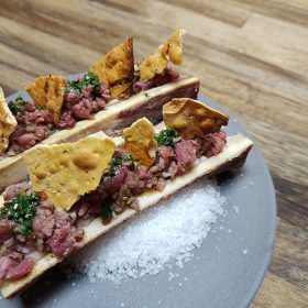 Gerookte mergpijp van de kamado met steak tartaar, chimichurri en krokante toast.